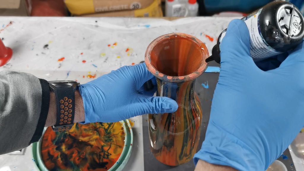applying uv resin to the edge of the vase that I sanded down from the resin drips for the resin pouring on glass vase